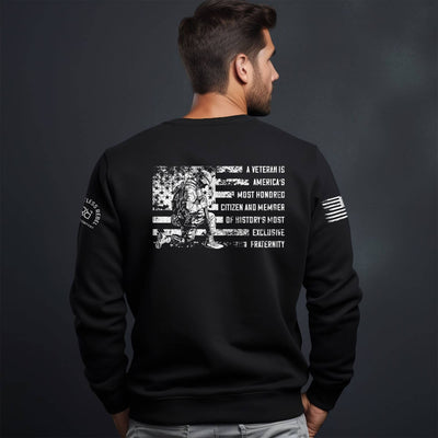 Black sweatshirt with text and graphic on the back, worn by a person against a dark background