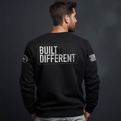 Man wearing solid black men's Built Different back design crew neck sweatshirt