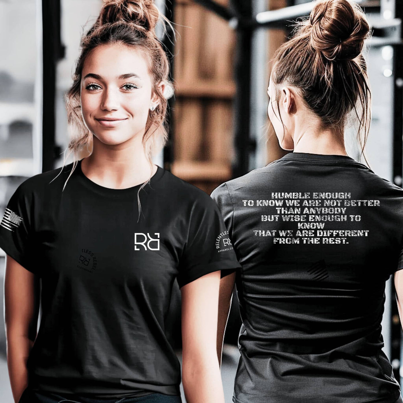 Woman wearing a black t-shirt with a logo on the front and text on the back, standing in a gym setting.
