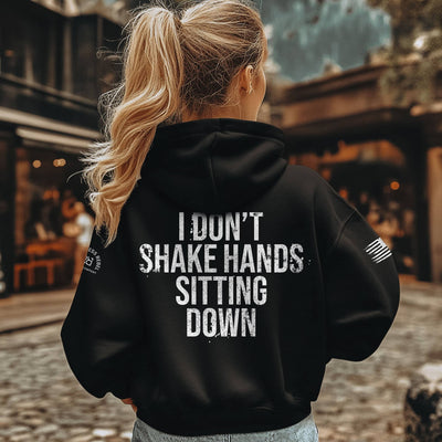 Person wearing a black hoodie with text on the back, standing outdoors.