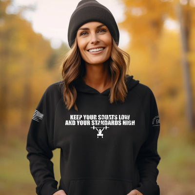 Woman wearing a black hoodie with motivational text in an autumn setting
