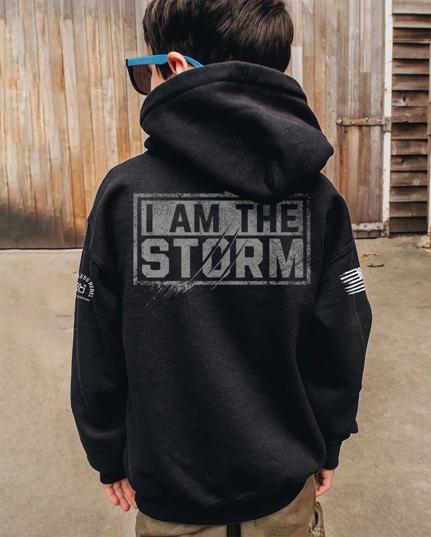 Boy wearing Solid Black Youth I Am The Storm Back Design Hoodie