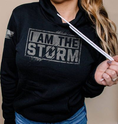 Woman wearing Solid Black Women's I Am The Storm Front Design Hoodie
