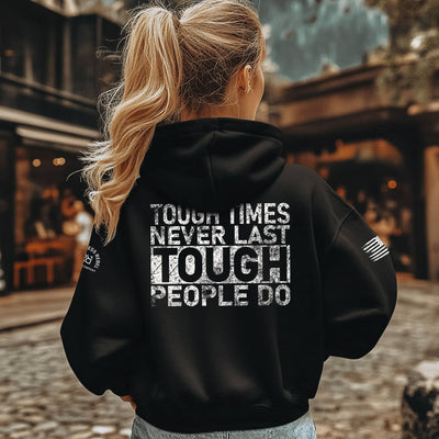 Person wearing a black hoodie with motivational text on the back, standing outdoors.