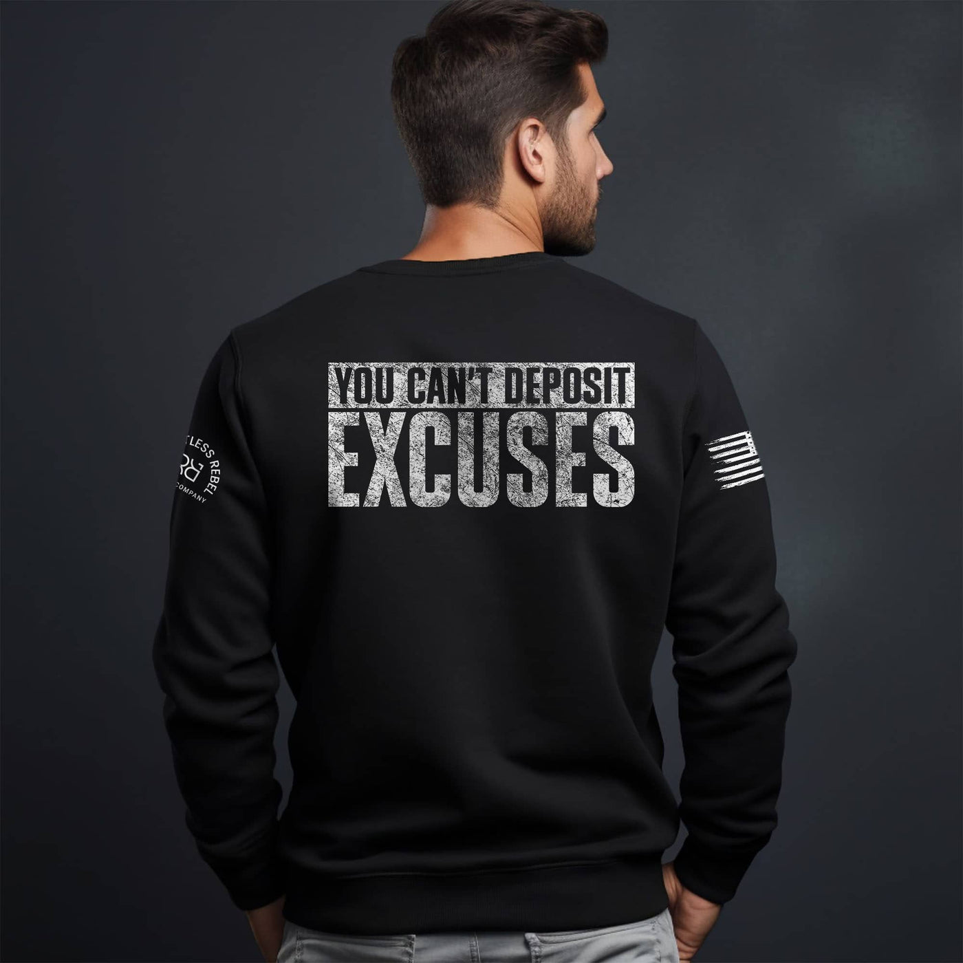 Man wearing a black sweatshirt with motivational text on the back against a dark background