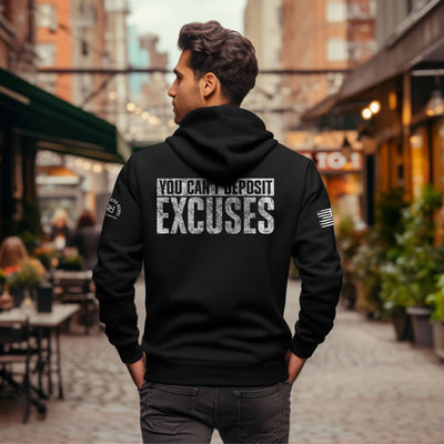 Person wearing a black hoodie with motivational text on the back in an urban setting