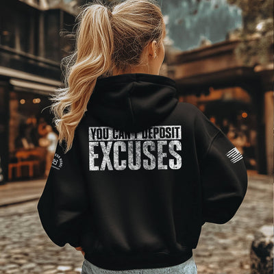 Person wearing a black hoodie with motivational text on the back, standing outdoors.