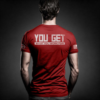 Man wearing Heather Red Men's You Get What You Work For Back Design Tee